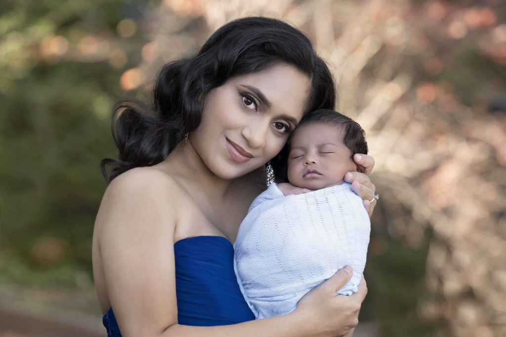 mother and newborn posing outdoors after retouching