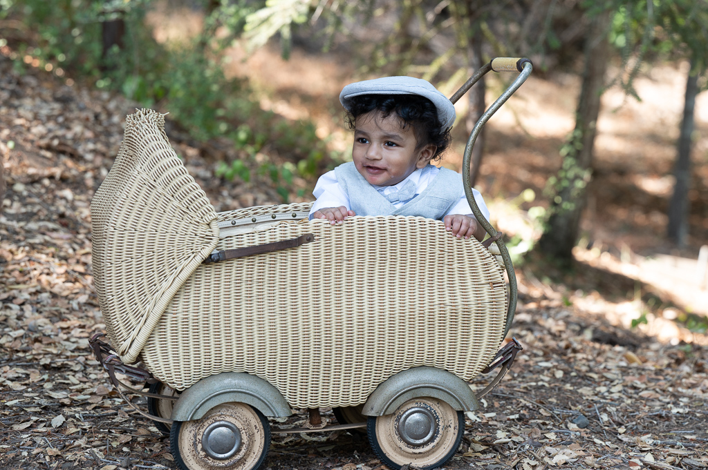 baby posing in old fashioned stroller outdoors before retouching