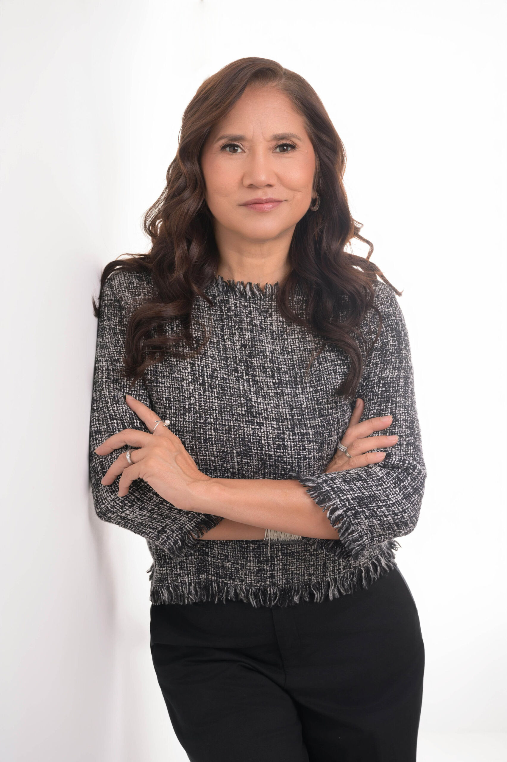 After Image: A woman with long hair wearing a gray sweater, standing with arms crossed against a white background.